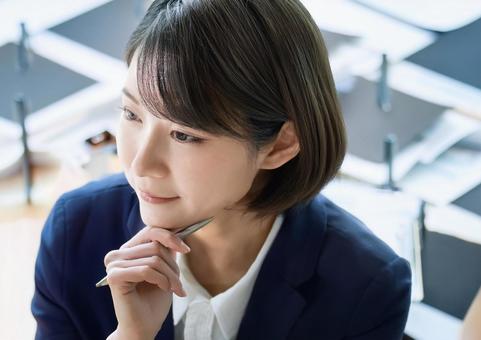 あごに手をやり考え事をする あごに手をやり考え事をするの写真