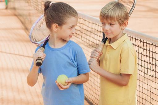 青いシャツの女の子と黄色のシャツの男の子の試合後シーン 男の子,女の子,外国人の写真素材