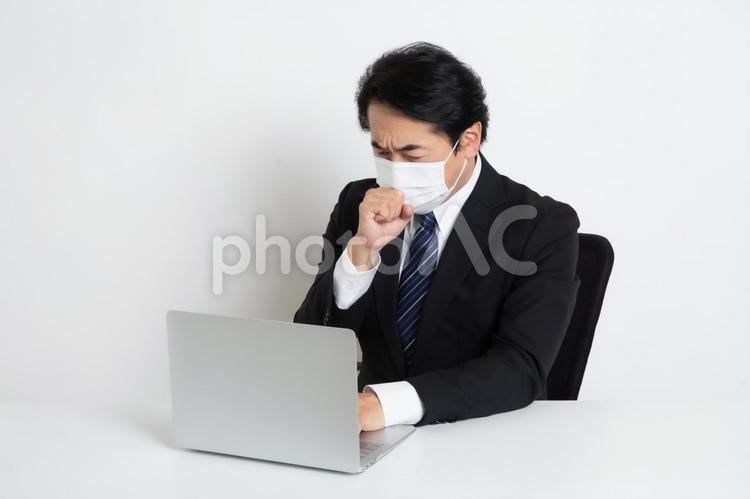 マスクをして悩みながら仕事をしている中年のサラリーマン男性 中年,上司,会社員の写真素材