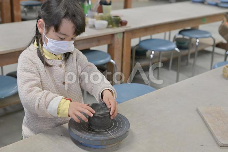 ろくろで陶芸作品を作るマスクの女の子７ 陶芸,マスク,ろくろの写真素材