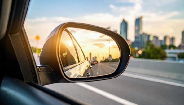 車のサイドミラーに映る道路と街並み 車のサイドミラーに映る道路と街並みの写真