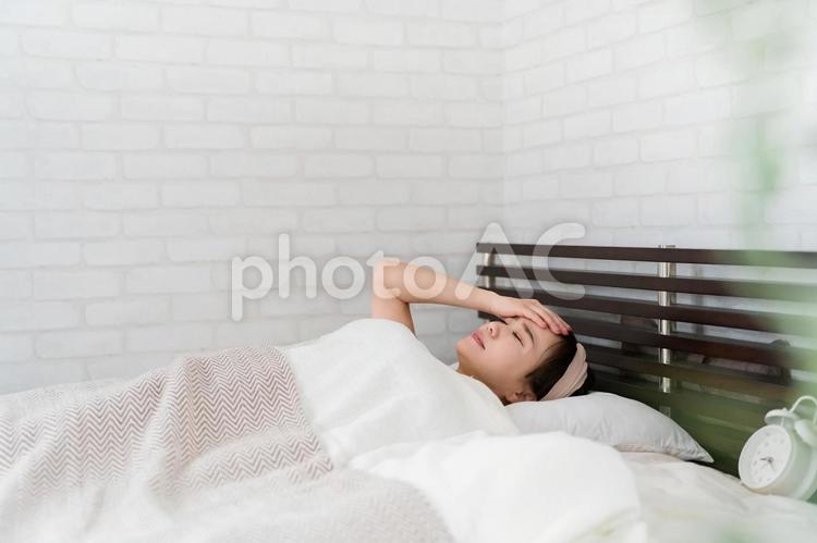 睡眠障害・眠れない女性（頭痛・発熱） 頭痛,発熱,不眠症の写真素材