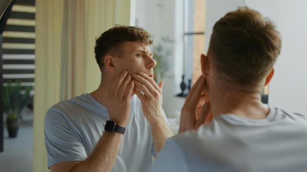 洗面所で鏡を見ている男性 鏡,映る,顔の写真素材