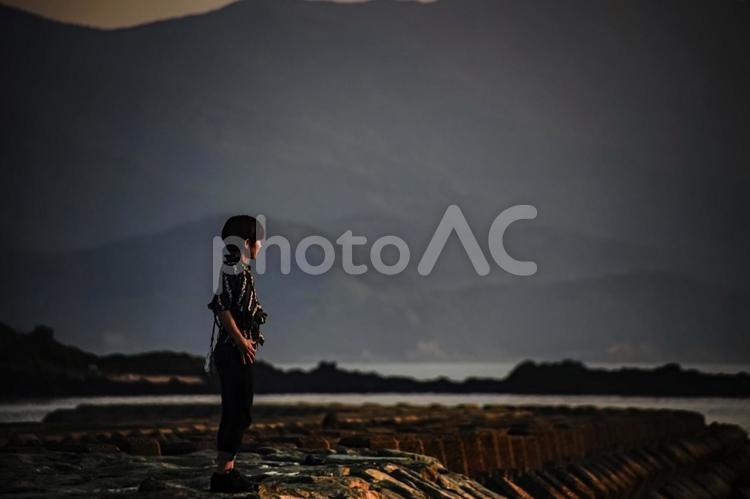＜素材＞夕方の堤防で孤独に海を眺める女性 女性,海,海岸の写真素材
