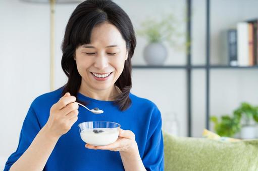 ヨーグルトを食べるミドルの女性 ヨーグルトを食べるミドルの女性の写真