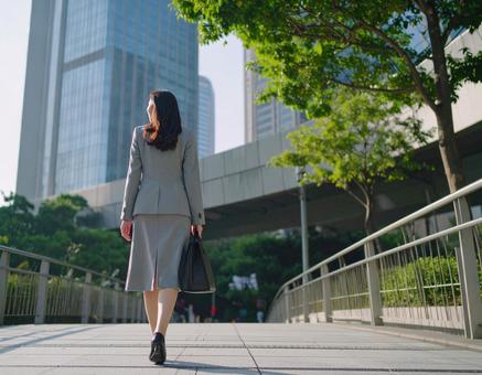 オフィス街を歩く女性 オフィス街を歩く女性の写真