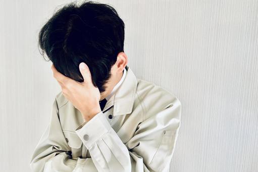 作業着を着た悩む男性ビジネスマン 悩む,困る,辛いの写真素材