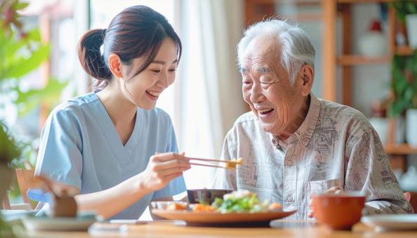 食事介助をする女性介護士と高齢男性 食事介助をする女性介護士と高齢男性の写真