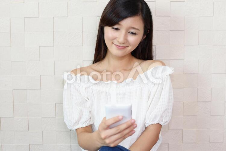 スマートフォンを持つ笑顔の女性 女性,スマートフォン,女の写真素材