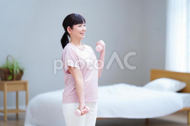 明るい室内で笑顔でトレーニングする中年女性 主婦,シニア,立ち姿の写真素材