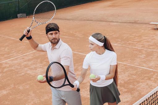 クレイコートで練習する男女のテニス風景 男女,外国人,テニスの写真素材