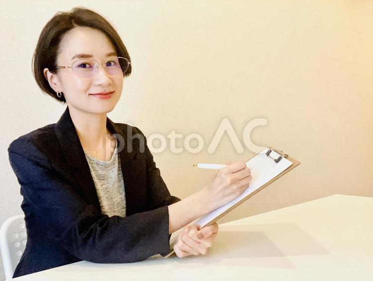 メモをとるスーツ姿のビジネスウーマン 女性,インタビュー,ビジネスの写真素材