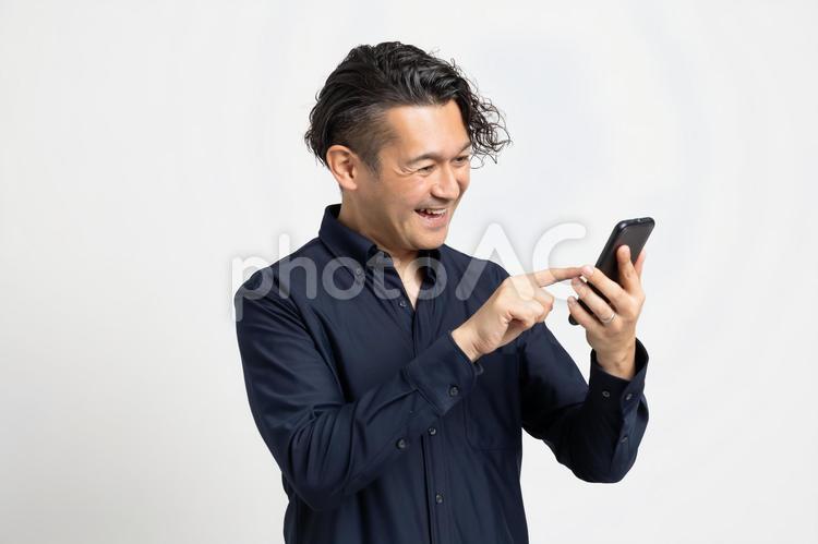 楽しそうにスマホ検索をする男性 ハーフ,スペイン人,日本人の写真素材