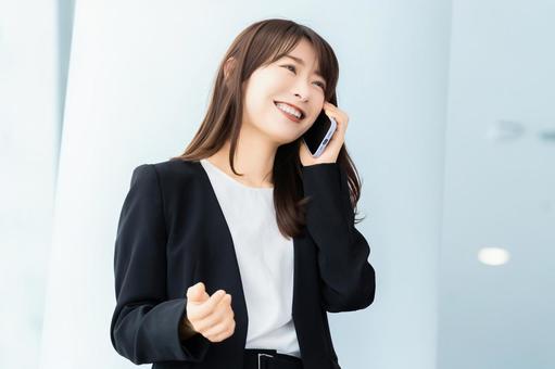 スマホで話す笑顔の女性・ビジネスウーマン 女性,スマホ,スマートフォンの写真素材
