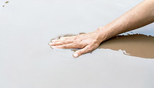 泥水を触る手 泥水を触る手の写真