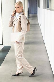 オフィスの通路で電話する横向きのビジネスウーマン ビジネスウーマン,ビジネス,女性の写真素材