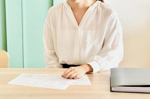 リビングで資料を見る女性 リビングで資料を見る女性 デスク,書類,資料の写真素材