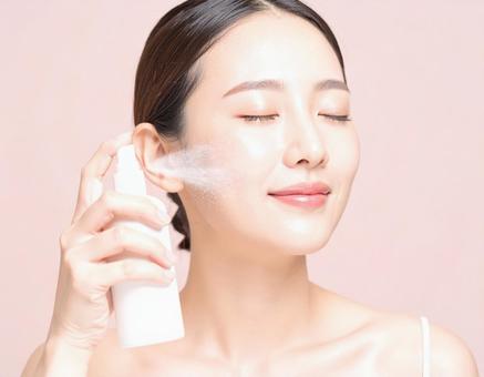 フェイスケアをする女性 フェイスケアをする女性の写真