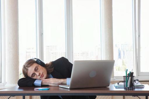 窓際の席で居眠り中の男性の写真