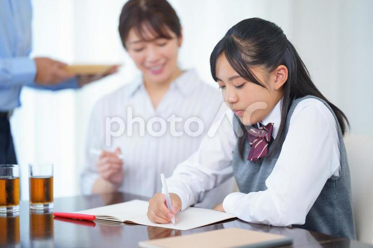 家庭教師と勉強する女の子にお茶を出すお父さん 人物,女の子,女子生徒の写真素材
