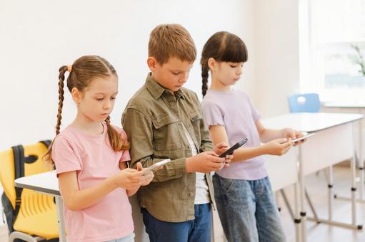 並んで携帯を見る生徒たち 男の子,女の子,子どもの写真素材