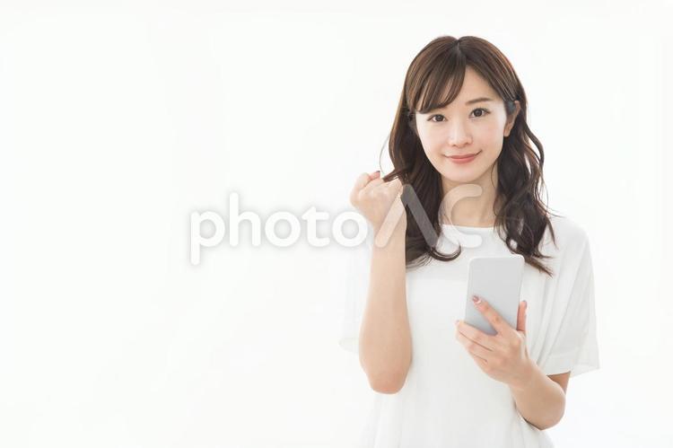スマートフォンを使う女性　 女性,人物,ガッツポーズの写真素材