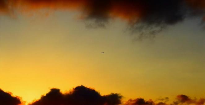 残暑の夕暮れに浮かぶ飛行機 残暑の夕暮れに浮かぶ飛行機の写真