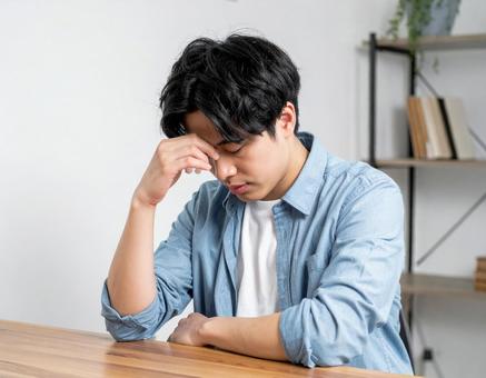 頭を抱える若い男性 頭を抱える若い男性の写真