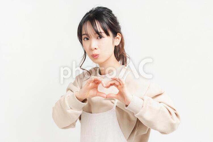 手でハートの形を作る若い女性 女性,ハート,気持ちの写真素材