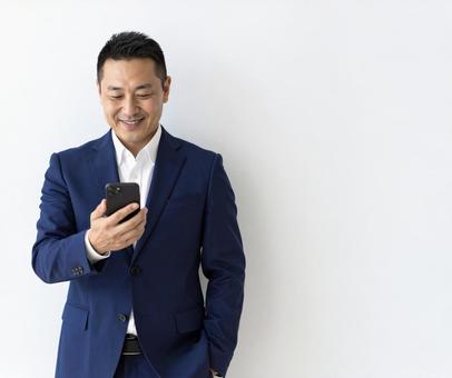 スマホ 50代 笑顔 嬉しい知らせ スマホ 50代 笑顔 嬉しい知らせ の写真