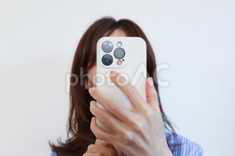 スマホで自撮りをする女性 スマホ,自撮り,セルフィーの写真素材