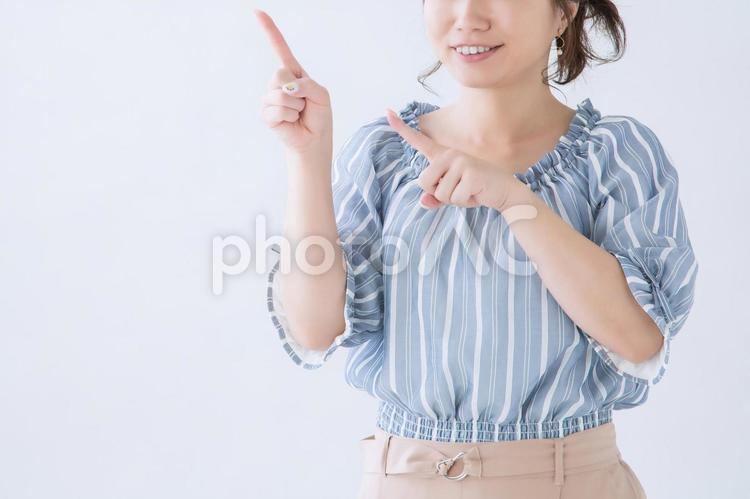 横を指さす女性 横,おすすめ,指さすの写真素材