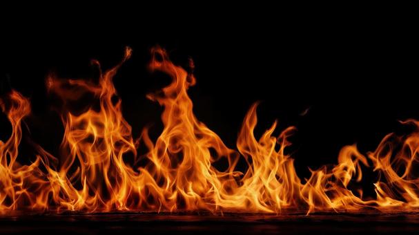 黒背景で地面から燃え盛る炎の写真