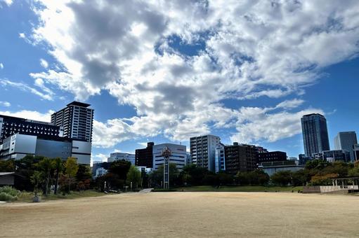 青空とビル群とグラウンド_711Cの写真