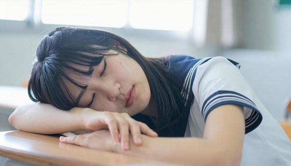 教室で寝る女子高生 教室で寝る女子高生の写真
