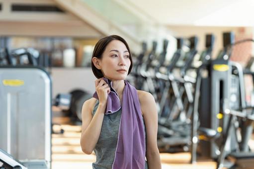 ジムでトレーニングするミドルの女性の写真