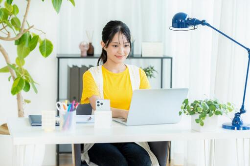 ノートパソコンを使う若い女性 笑顔,若い女性,ビジネスウーマンの写真素材