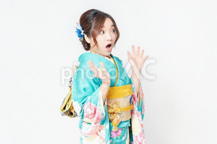 白背景の前に立って、驚いたポーズをする振袖を着た女性 女性,サプライズ,驚くの写真素材