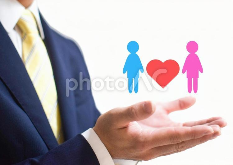 カップルを両手で大事にもつビジネスマン ビジネスマン,会社員,男性の写真素材