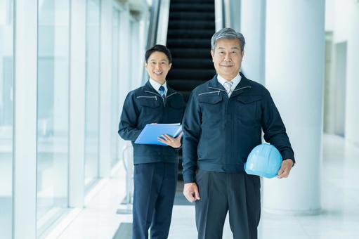 現場で打ち合わせする作業服のビジネスマン 現場で打ち合わせする作業服のビジネスマン 作業服,ビジネスマン,ヘルメットの写真素材