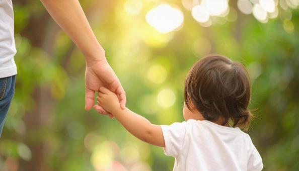 手を繋いで公園を歩く親子の手 手を繋いで公園を歩く親子の手の写真