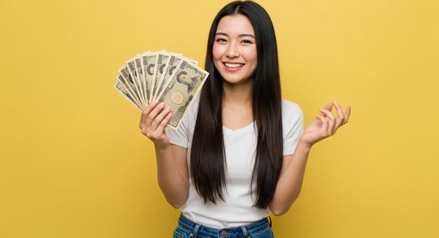 大金を手にして喜ぶ女性 大金を手にして喜ぶ女性の写真