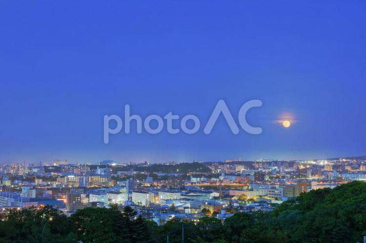 満月と街並み(広め) 満月,月,ピンクムーンの写真素材