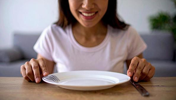 食後、空になったお皿を前に笑顔の女性 食後、空になったお皿を前に笑顔の女性の写真