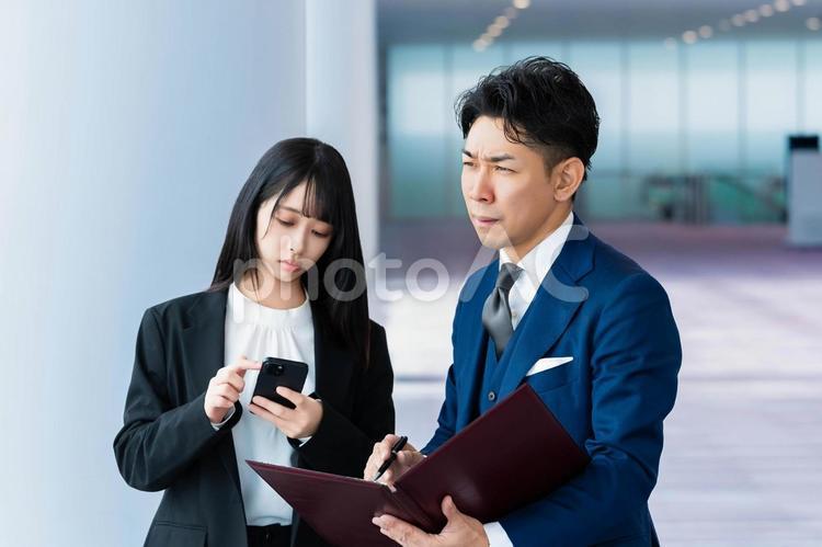 廊下で打ち合わせをする部下と上司 ビジネスウーマン,ビジネスマン,女性の写真素材