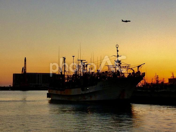 夕焼け　漁船と飛行機 海,空,釣りの写真素材