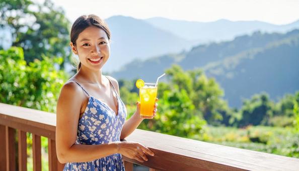 高原の朝オレンジジュースを飲む女性 高原の朝オレンジジュースを飲む女性の写真