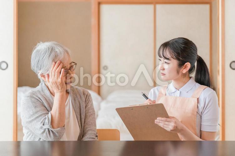 在宅介護を受ける高齢者女性（頭痛・発熱） 高齢者,訪問医療,在宅医療の写真素材