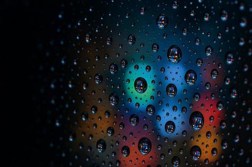 夜の街並みに映る雨粒の写真