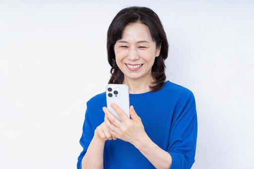 スマホを使うミドルの女性 スマホを使うミドルの女性 スマートフォン,スマホ,携帯の写真素材